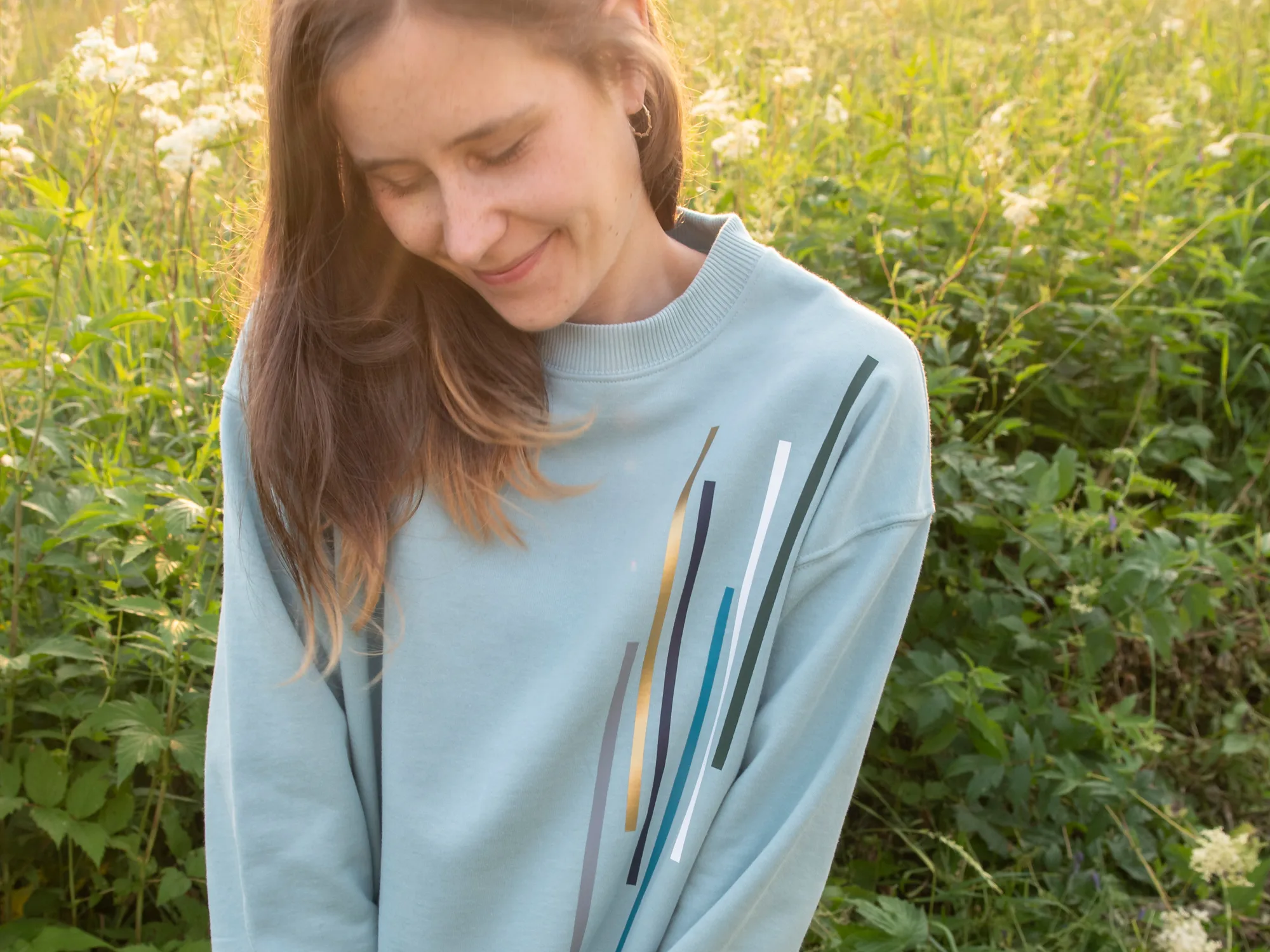 bambiboom Faire Mode, Model mit bedrucktem Sweatshirt in sommerlicher Blumenwiese